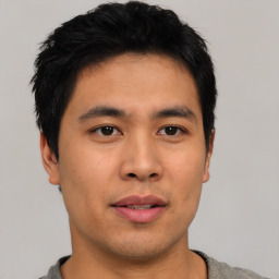 Joyful asian young-adult male with short  black hair and brown eyes