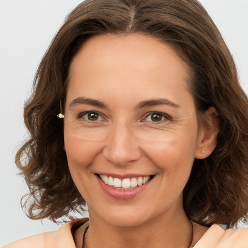 Joyful white adult female with medium  brown hair and brown eyes