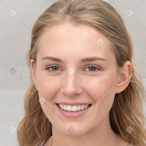 Joyful white young-adult female with long  brown hair and blue eyes