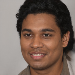 Joyful black young-adult male with short  black hair and brown eyes