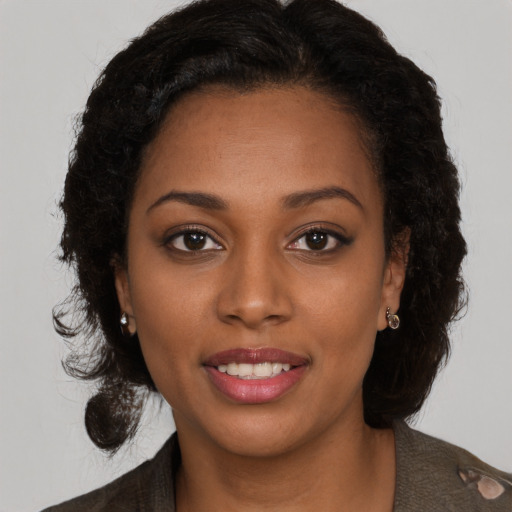 Joyful black young-adult female with long  brown hair and brown eyes