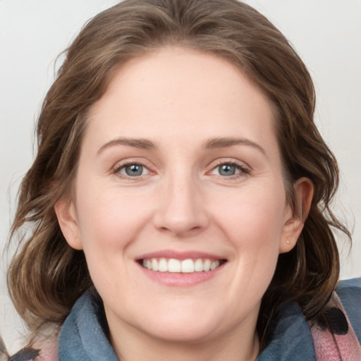 Joyful white young-adult female with medium  brown hair and blue eyes