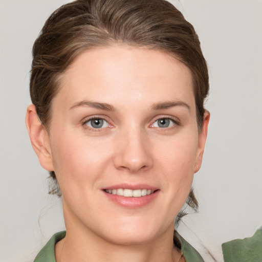 Joyful white young-adult female with medium  brown hair and grey eyes