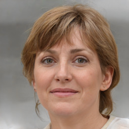 Joyful white adult female with medium  brown hair and blue eyes