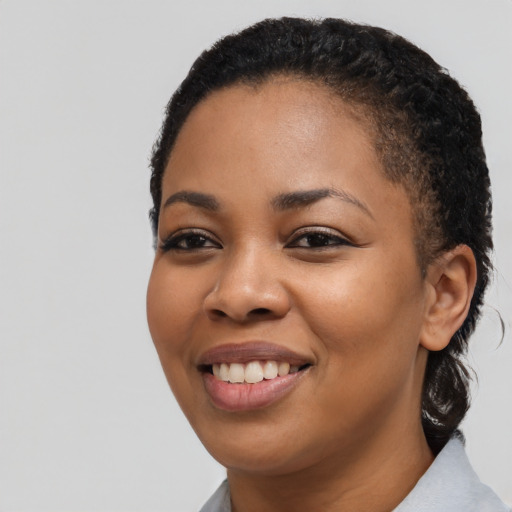 Joyful black young-adult female with short  black hair and brown eyes