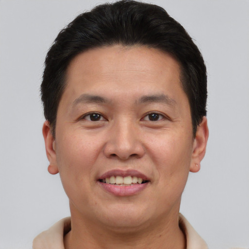 Joyful asian adult male with short  brown hair and brown eyes