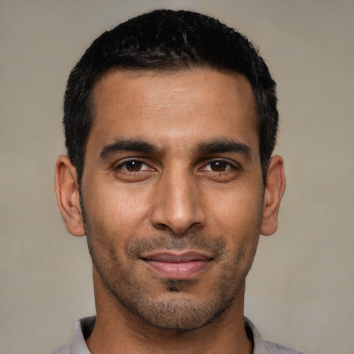 Joyful latino young-adult male with short  black hair and brown eyes