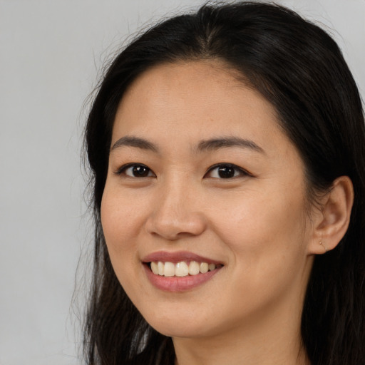 Joyful asian young-adult female with long  brown hair and brown eyes