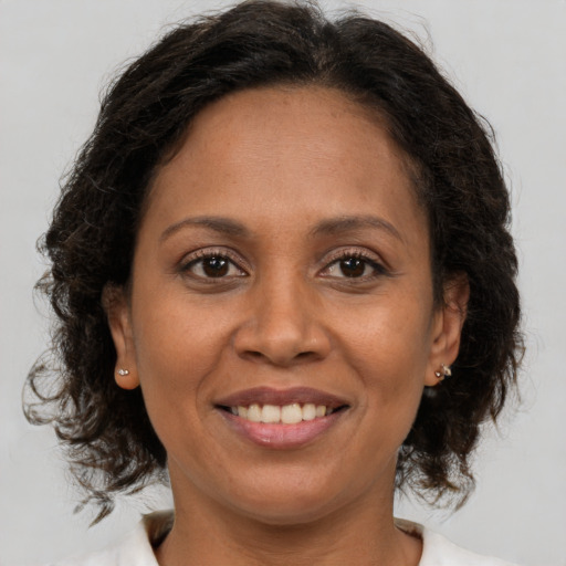 Joyful black adult female with medium  brown hair and brown eyes