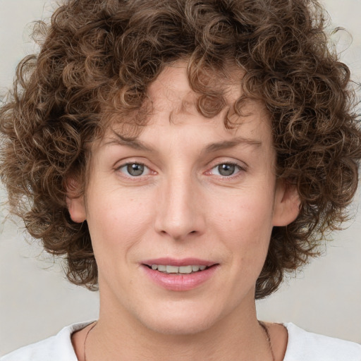 Joyful white young-adult female with medium  brown hair and green eyes