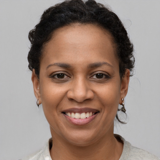 Joyful latino adult female with short  brown hair and brown eyes