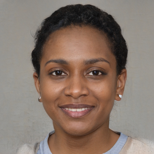 Joyful black young-adult female with short  black hair and brown eyes