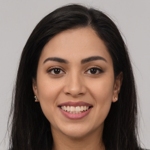 Joyful latino young-adult female with long  brown hair and brown eyes