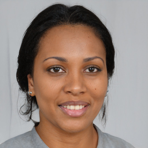Joyful black young-adult female with medium  brown hair and brown eyes