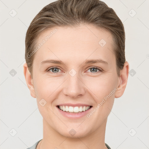 Joyful white young-adult female with short  brown hair and grey eyes