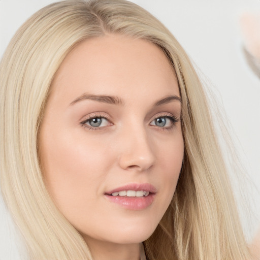 Joyful white young-adult female with long  blond hair and brown eyes