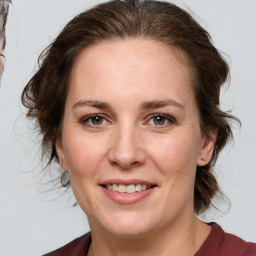 Joyful white adult female with medium  brown hair and grey eyes