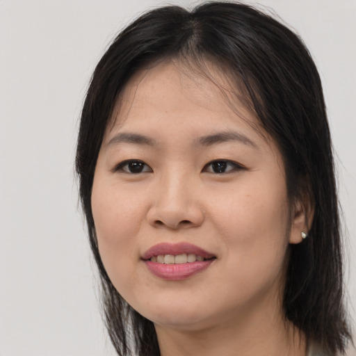Joyful asian young-adult female with long  brown hair and brown eyes