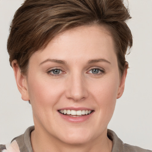 Joyful white young-adult female with short  brown hair and grey eyes