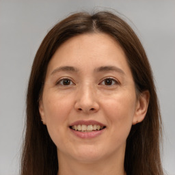 Joyful white adult female with long  brown hair and brown eyes