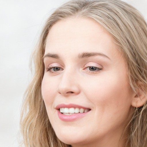 Joyful white young-adult female with long  brown hair and blue eyes