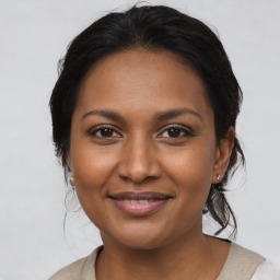 Joyful black young-adult female with medium  brown hair and brown eyes