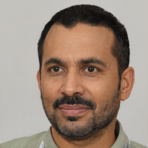 Joyful black adult male with short  black hair and brown eyes