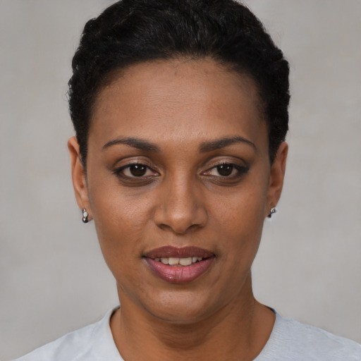 Joyful black young-adult female with short  black hair and brown eyes