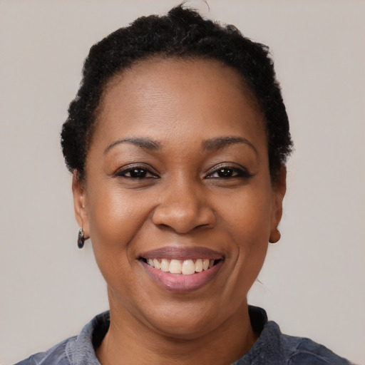Joyful black adult female with short  black hair and brown eyes