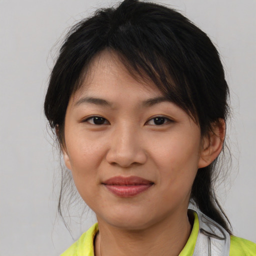 Joyful asian young-adult female with medium  brown hair and brown eyes