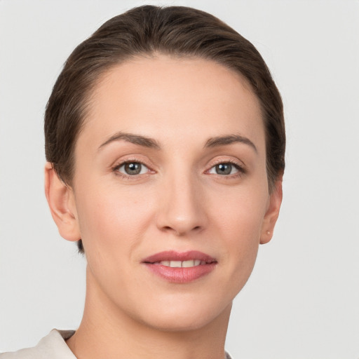 Joyful white young-adult female with short  brown hair and grey eyes