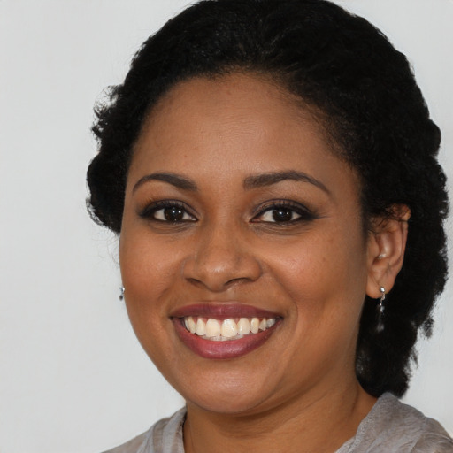 Joyful black young-adult female with medium  brown hair and brown eyes