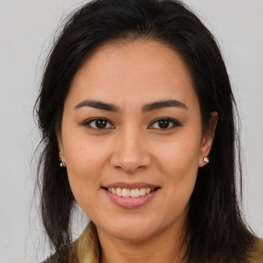 Joyful latino young-adult female with long  brown hair and brown eyes