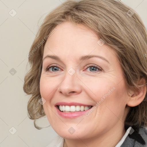 Joyful white adult female with medium  brown hair and blue eyes