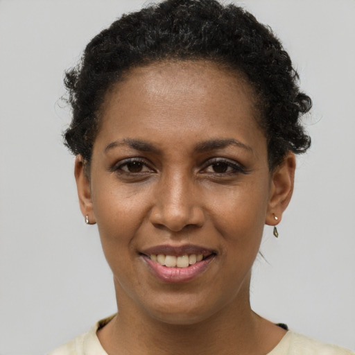 Joyful black young-adult female with short  brown hair and brown eyes