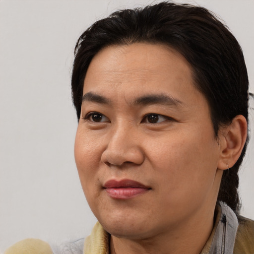 Joyful asian adult male with medium  black hair and brown eyes