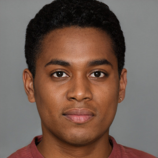 Joyful black young-adult male with short  brown hair and brown eyes