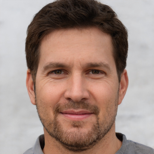 Joyful white adult male with short  brown hair and grey eyes