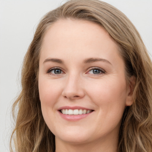 Joyful white young-adult female with long  brown hair and green eyes