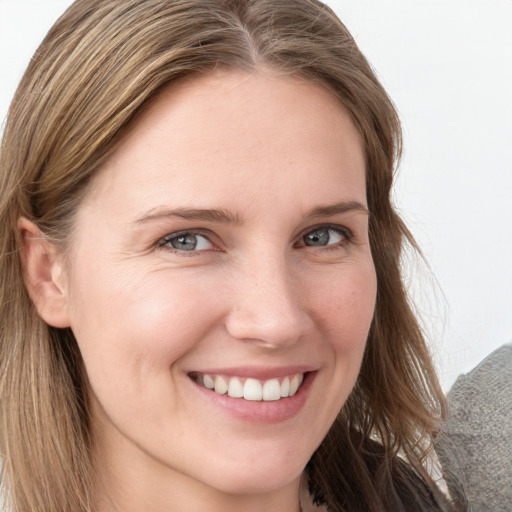 Joyful white young-adult female with long  brown hair and blue eyes