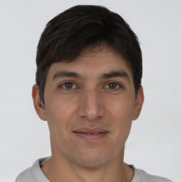 Joyful white young-adult male with short  black hair and brown eyes