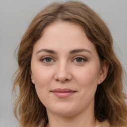 Joyful white young-adult female with medium  brown hair and green eyes