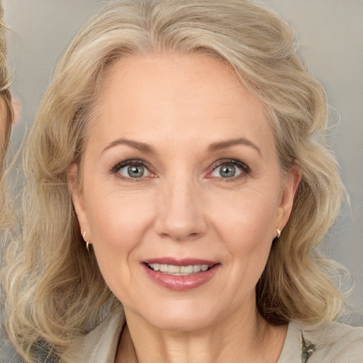 Joyful white adult female with medium  brown hair and blue eyes