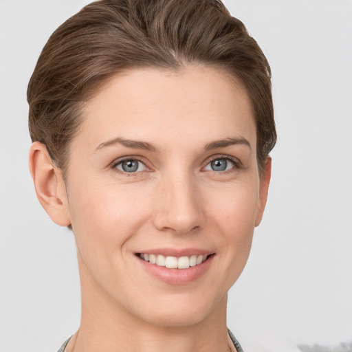 Joyful white young-adult female with short  brown hair and grey eyes