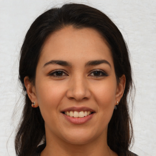 Joyful latino young-adult female with long  brown hair and brown eyes