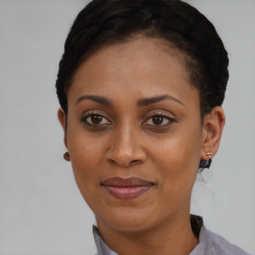 Joyful black young-adult female with short  brown hair and brown eyes
