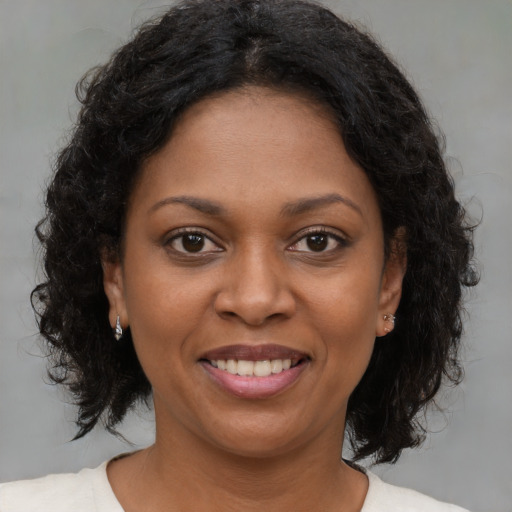 Joyful black young-adult female with medium  brown hair and brown eyes