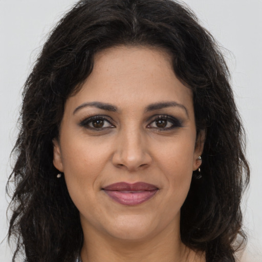 Joyful latino adult female with long  brown hair and brown eyes