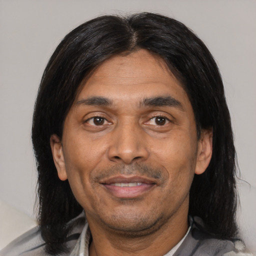 Joyful latino adult male with medium  black hair and brown eyes