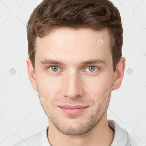 Joyful white young-adult male with short  brown hair and grey eyes